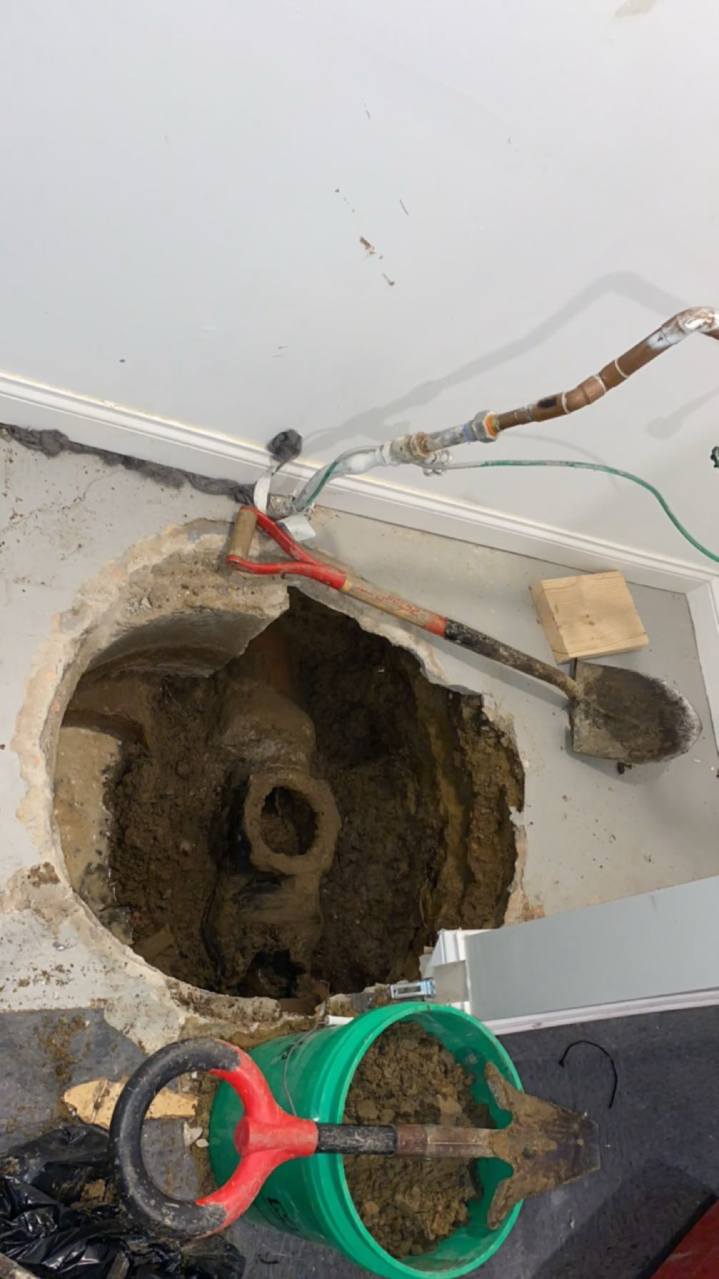 Chicago basement sewer repair — concrete floor cut open and dug down to a broken clay sewer line
