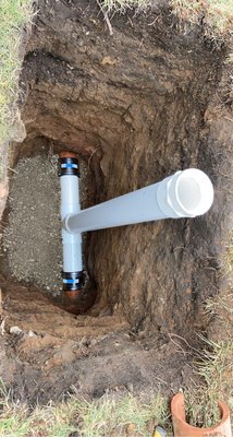Newly installed cleanout fitting in an excavated hole