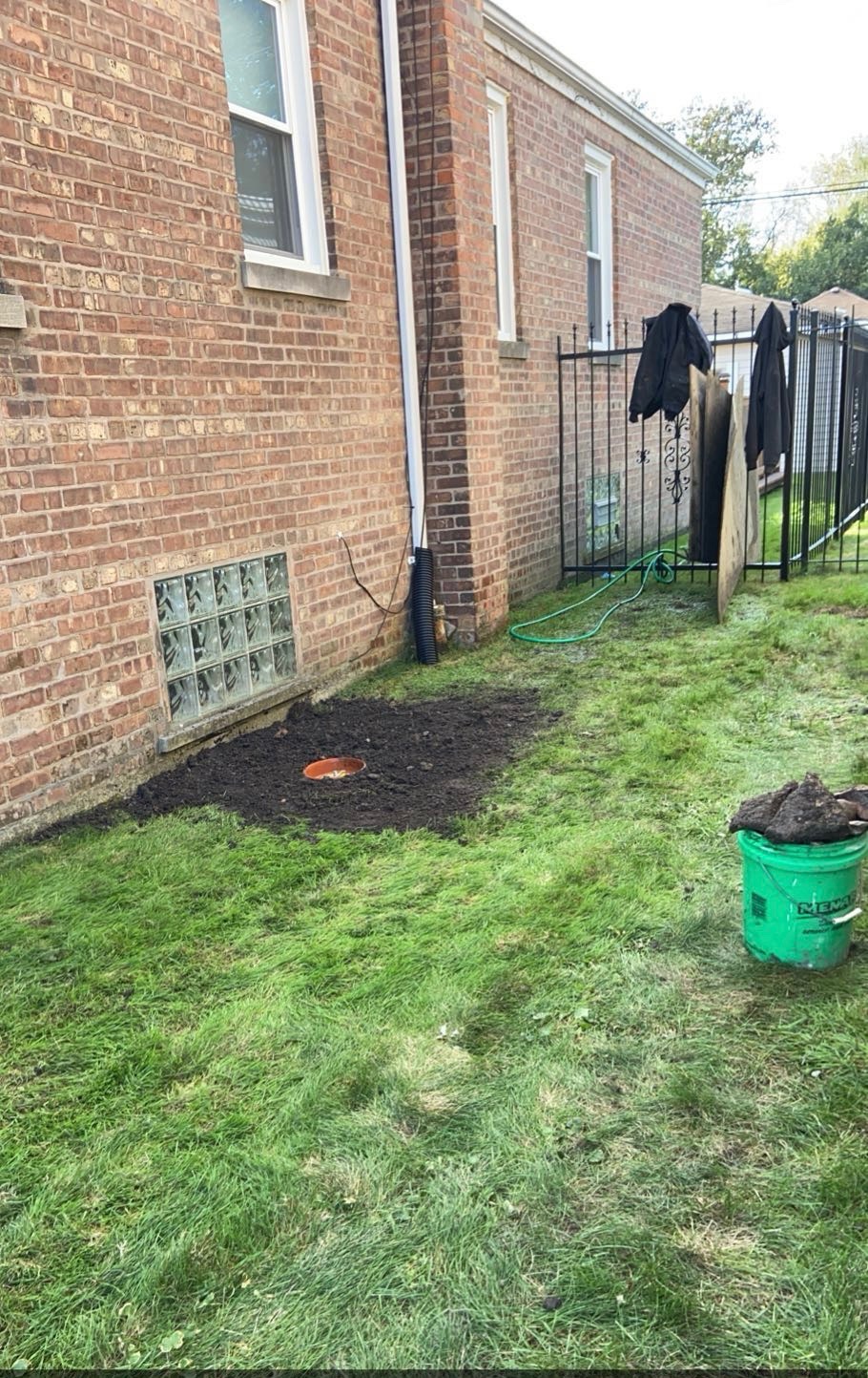 Same Chicago side yard backfilled and graded with only the cleanout cap showing at grade