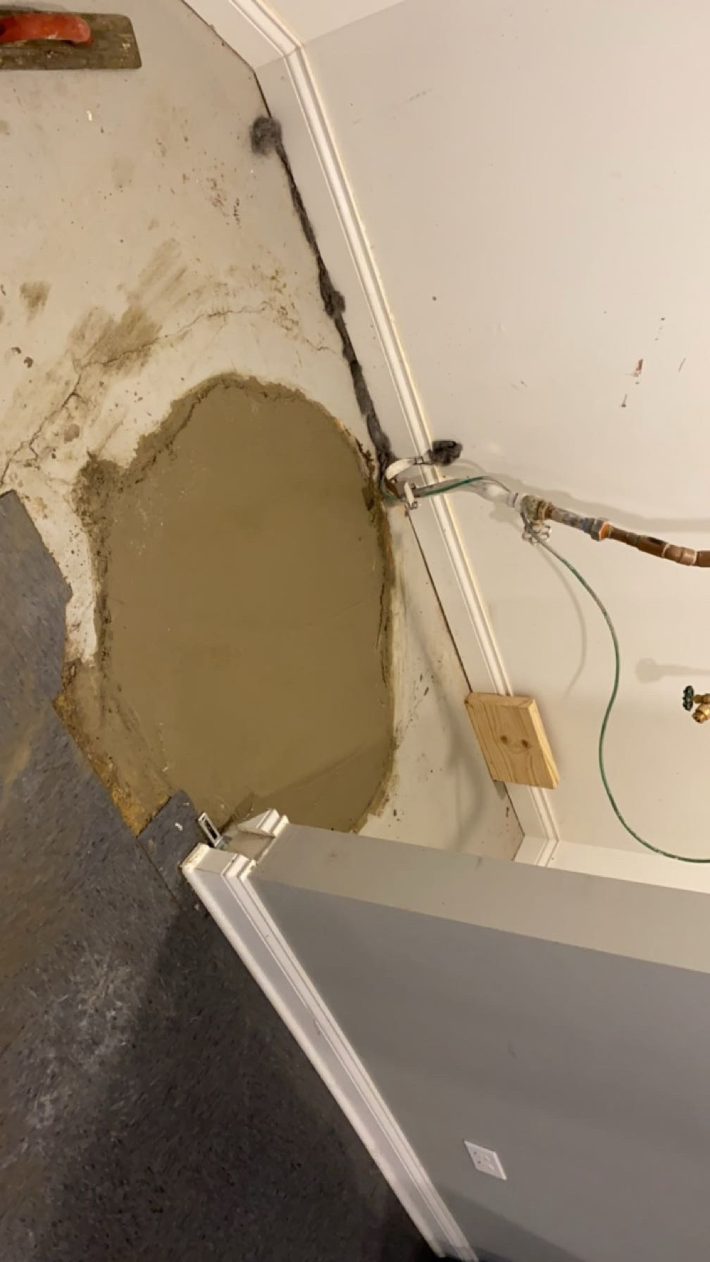 Basement floor patched with fresh concrete after the sewer line repair