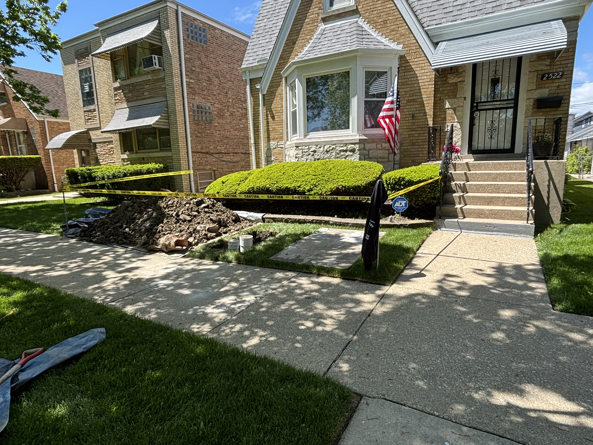 Chicago flood control install — Clean Check backwater valve job with fresh spoils and PVC risers in the front yard