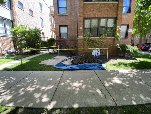 Open trench with tarp during a Chicago sewer line repair